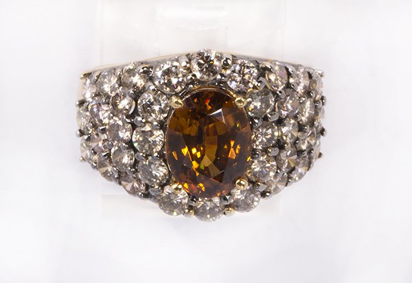Brown zircon, diamond and 18k yellow gold ring: Brown zircon, diamond and 18k yellow gold ring centering one oval brown zircon, weighing approximately 3.00 cts., accented by (36) full-cut diamonds, weighing a total of approximately 1.80 cts., set i