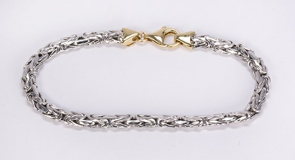 Platinum and 18k yellow gold bracelet: Platinum and 18k yellow gold bracelet the platinum flattened Byzantine link, measures approximately 5.0 mm in width, completed by an 18k yellow gold lobster clasp and caps, forming a 7" bracelet, mark