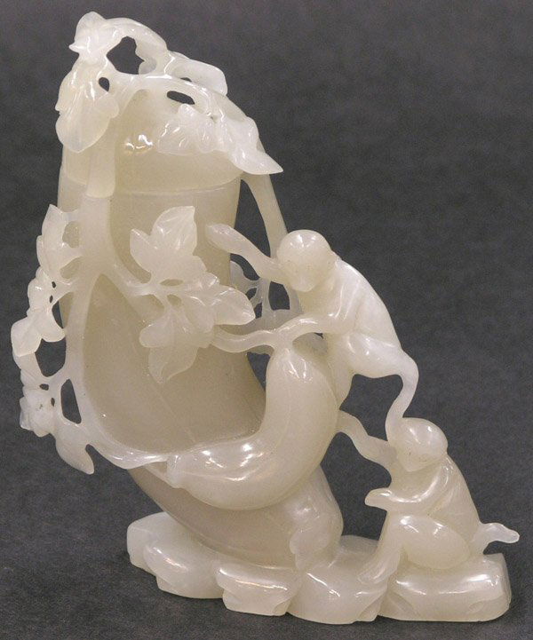 Chinese white jade urn with monkeys: Chinese mutton fat jade covered urn, carved and pierced as a pair of maonkeys attempting to climb an oversize bitter melon encircled by leafy vines extending over the fitted lid, the translucent greyi