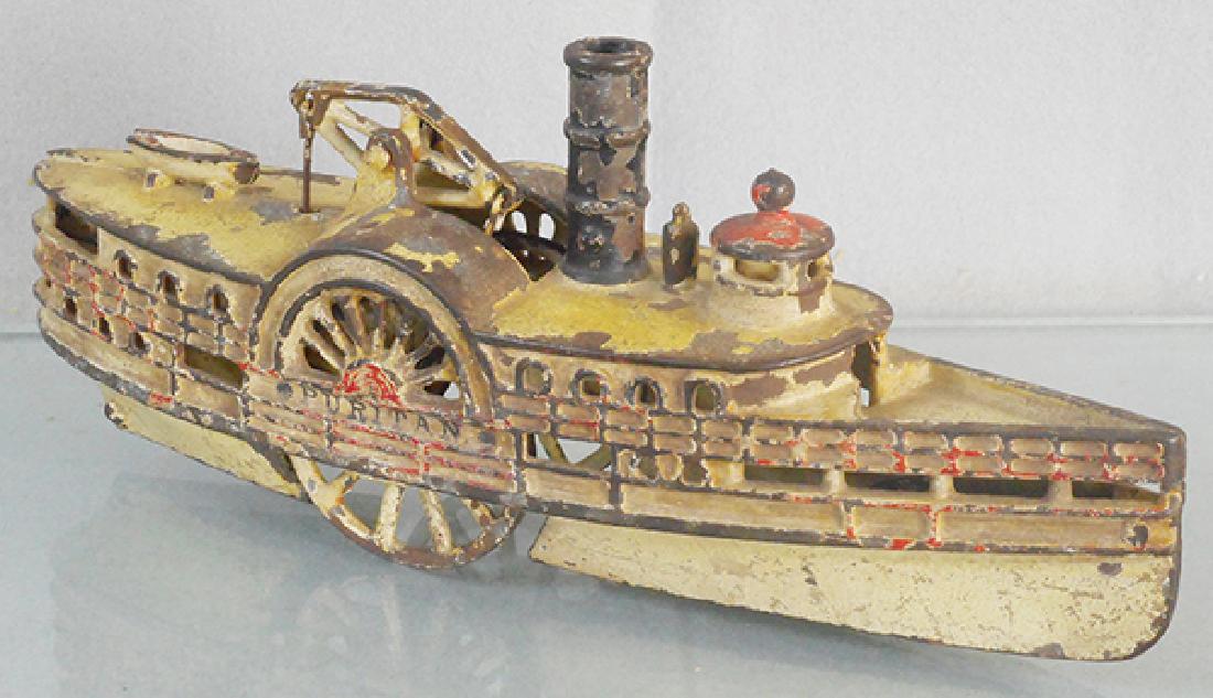 WILKINS PURITAN PADDLEBOAT: painted cast iron, 11 in long, w/eccentric front wheel and walking beam, C4.