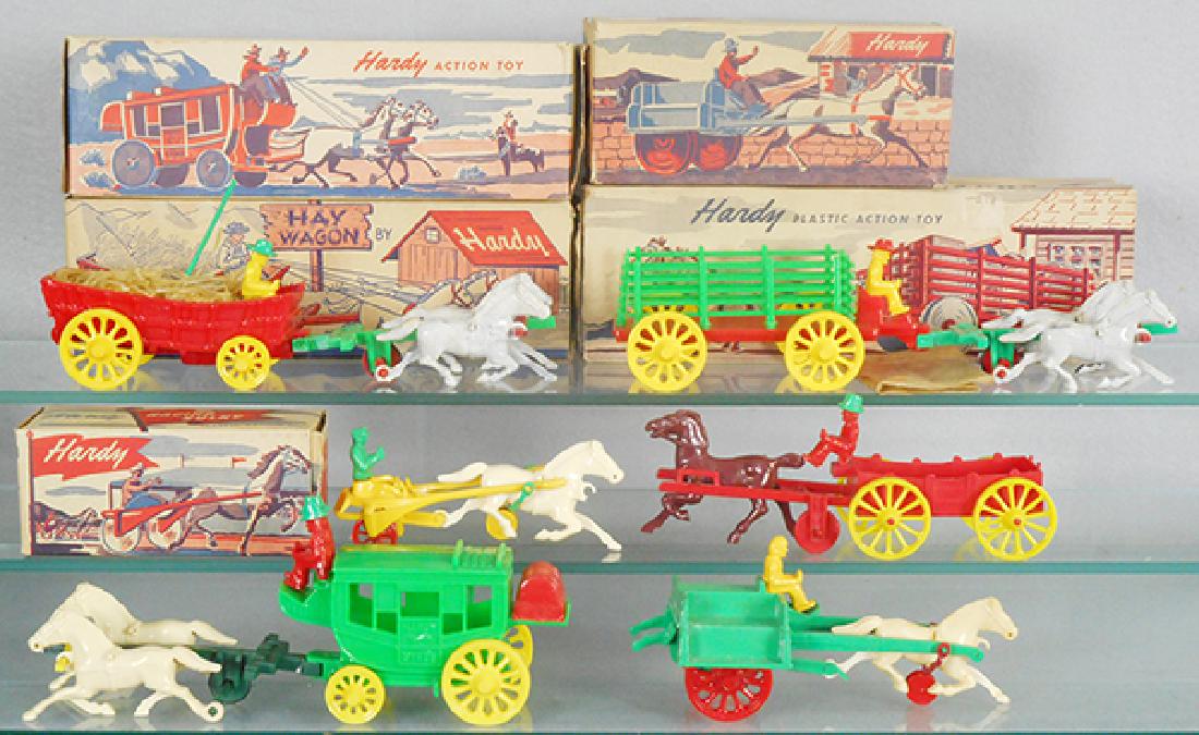 6 HARDY PLASTICS HORSE-DRAWN VEHICLES: Stagecoach, Hay Wagon, Stake Wagon, Jaunting Cart, Racing Sulky, all these have worn orig boxes, longest wagon is 11 in long, w/extra dump cart, C8-9.