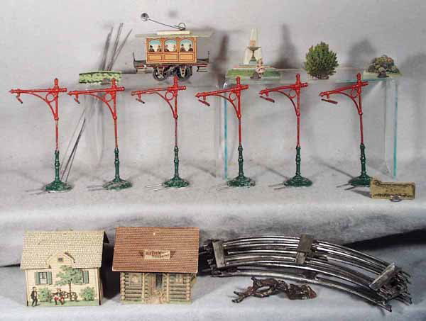ISSAMEYER TROLLEY SET: O ga, trolley is lithographed tin, windup working, 4 1/2 in long, some old solder repairs holding motor in place, w/6 catanary poles, paint flaking on bases & 6 wires, track circle & some Pretty Villa
