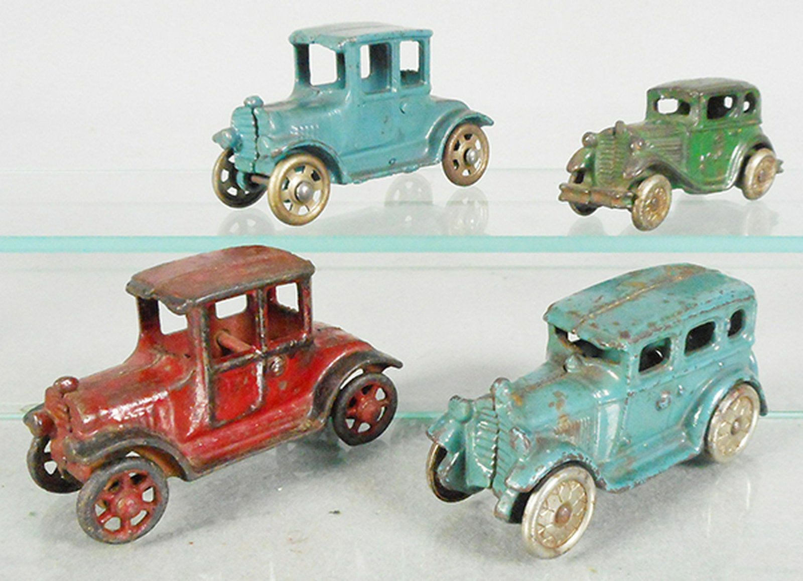 4 AC WILLIAMS AUTOS: painted cast iron, Model T, blue, 4 in long, Austin, green, 3 3/4 in long, Model T, red, 4 in long, some touch up, Sedan, blue, 4 in long, C4-6.