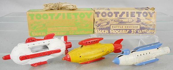 3 TOOTSIETOY BUCK ROGERS SPACE SHIPS: 1033 Attach Ship, white & red, w/orig string & box, 1032 Venus Duo Destroyer, yellow & red, 1031 Battle Cruiser, blue & white, w/worn orig box, C6-8.