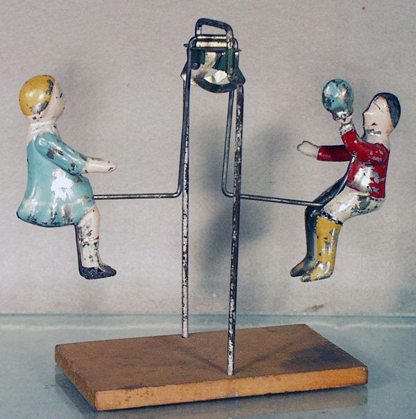 GIBBS SEE SAW: painted tin & wood, 6 1/2 in tall, some paint flaking on figures, C5. Please read and understand the Terms & Conditions before bidding.