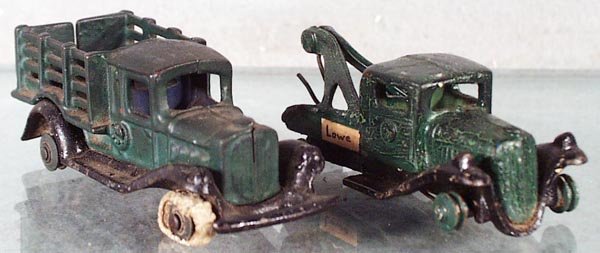 2 CHAMPION TAKE-APART TRUCKS: painted cast iron, Stake Truck, 4 1/2 in long, Wrecker, 4 in long, both are repainted & have either worn or no rubber tires, no breaks, C1.