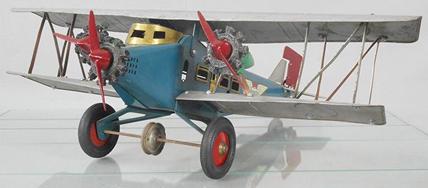 AMERICAN FLYER 567 SKY KING AIRPLANE: painted pressed steel, 23 in wingspan, 8 in tall, 21 in long, silver & blue w/brass trim, trimotor, propellers are reproductions, propellers spin when plane is moved, rear horizontal tail wing is repa