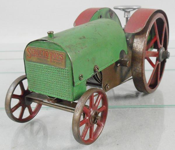 STRUCTO 11 TRACTOR: painted pressed steel, red & green, 10 in long, steering wheel replaced, triple spring motor, windup working, C6-7.
