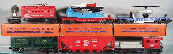 061: 7 LIONEL FREIGHT CARS: O ga, 3535 security car, orig box; 6650 missile launching car, missile broken, orig box; 3419 helicopter car, w/repro helicopter; 3370 Wells Fargo; 6736 D&M hopper; 6119 work caboose; 3370 turbo missi