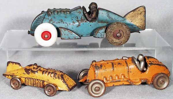 3 HUBLEY RACERS: painted cast iron, blue Racer, 7 in long, 1 back fin broken off, 2 new tires, 2 old tires rough; yellow Racer, 4 1/4 in long, metal wheels; orange Racer, 5 1/4 in long, nickel driver & wheels, C3-4.