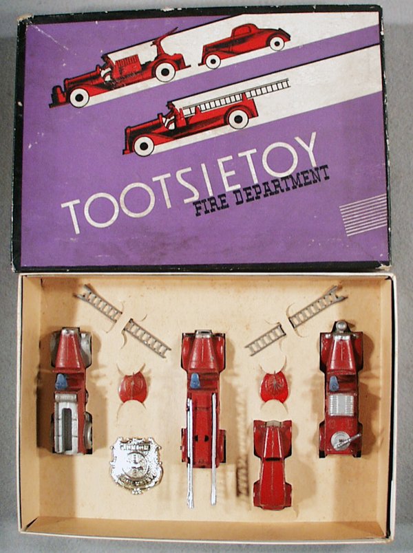 TOOTSIETOY 411 FIRE DEPARTMENT SET: contains 1041 Mack Hose Car w/4 flat tires, 1040 Mack Hook & Ladder, 111 Ford Sedan, 1042 Insurance Patrol, Badge, 2 Helmets, orig set box & insert minor wear, C5-7.