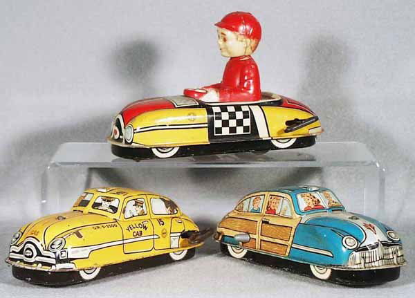 3 MARX AUTOS: painted pressed steel, Auto w/celluloid boy driver, windup not working, 6 3/4 in long, boy's head glued; Yellow Cab, windup working, 6 3/4 in long; Woody Wagon, windup working, 6 3/4 in long, C5.