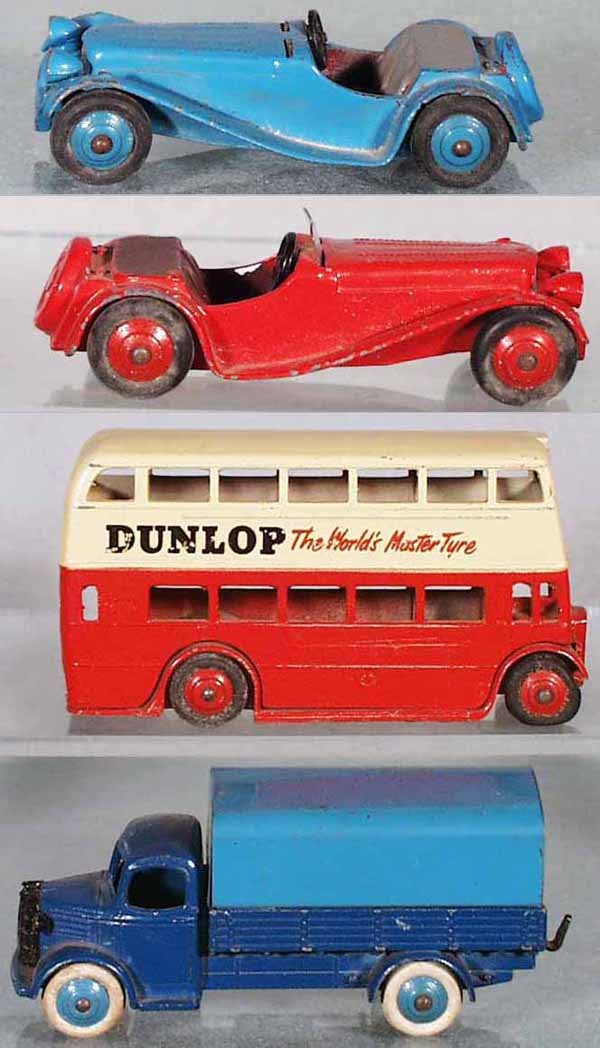 4 DINKY VEHICLES: 2 #38F Jaguars, the blue one is missing both plastic windscreens; 290 Doubledecker Bus, mildew & wear to tires, light wear to decals; 30S Austin Covered Truck, C5-6.