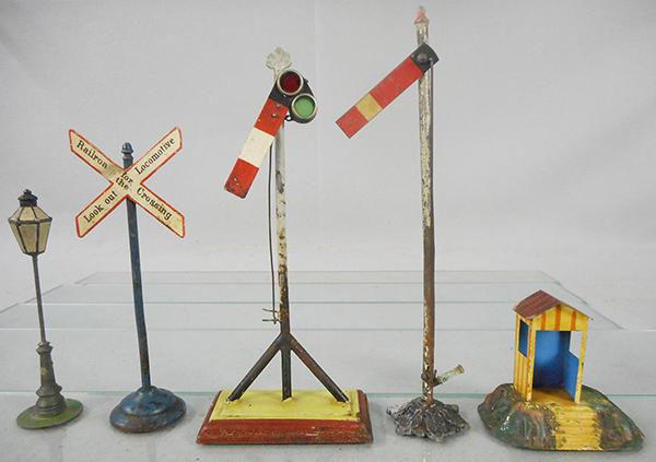 5 GERMAN TRAIN ACCESSORIES: O ga, handpainted tin, Heyde lamp post, 6 1/2 in, Marklin RR crossing sign, 8 in, Marklin semaphore, 10 in, Bing semaphore, 11 in, floral base, Marklin Line Keeper's hut, 3 1/2 in, C4-5.