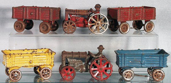 6 CAST IRON FARM VEHICLES: painted cast iron, Arcade Tractor w/2 Wagons, each 3 3/4 in long, playworn & heavy oxidation, C1-2; AC Williams Tractor & 2 Wagons, each 4 in long, some playwear, oxidation on tractor & wagon wheels,