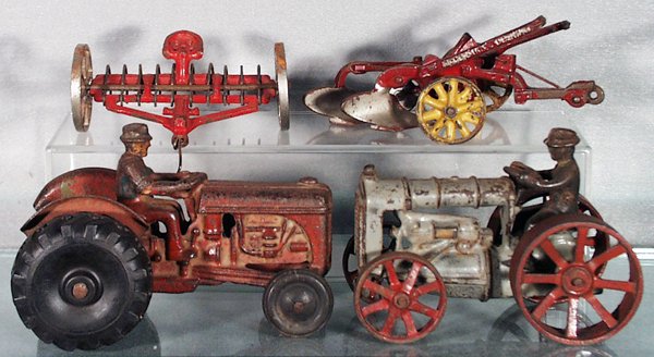4 ARCADE FARM VEHICLES: painted cast iron, Hay Rake, 3 1/2 in long, oxidation on nickel wheels & axle; McCormick-Deering Plow, 6 1/2 in long, playworn, some light oxidation on wheels; Tractor, 6 in long, incorrect tires, pla