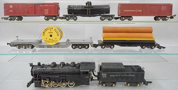 AMERICAN FLYER TRAIN SET: S ga, 342 switcher loco & tender w/smoke & choo choo, cab lettering worn, 717 operating log dump, 636 flat w/cable reel, 633 box car, 625 Shell tank, oxidation on trim, 642 box car, C5-7.