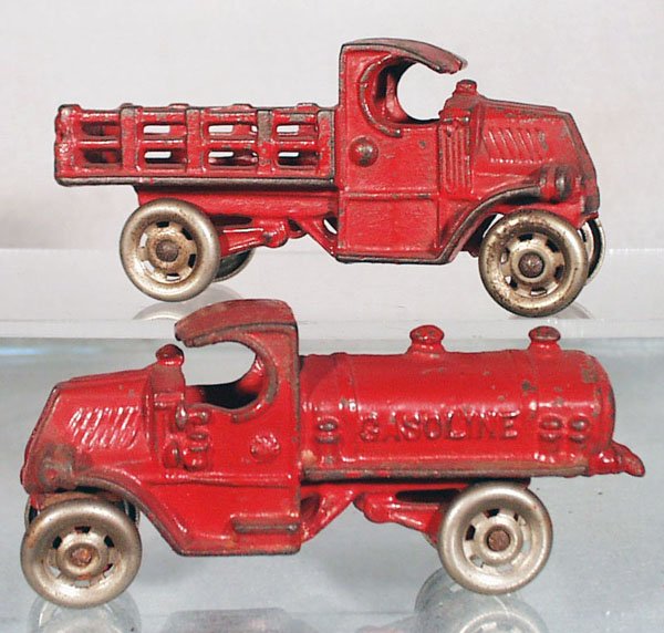 2 CHAMPION MACK TRUCKS: painted cast iron, nickel steel wheels, red, the Stake Truck is 4 3/4 in long, the Gasoline Truck is 5 in long, C4-5.