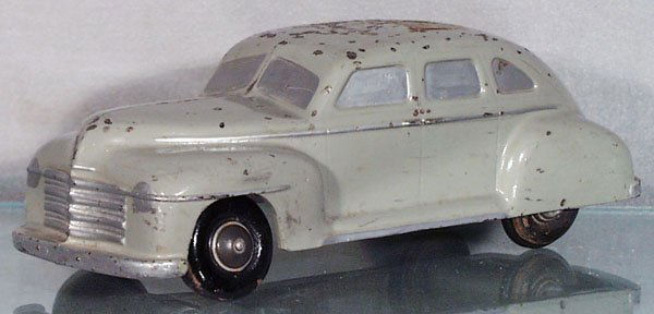 SETO OF SWEDEN 1947 PLYMOUTH: die cast, remote control drive car, wooden tires, paint chips on roof, 12 in long, insert rod into slot in roof & the car can be made to steer, 1 tire brace needs resoldering, C5.