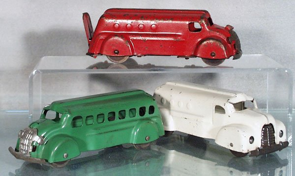 3 WYANDOTTE VEHICLES: painted pressed steel, wooden wheels, 6 1/4 in long, red Bank Truck, green Bus, w/Motor Oil rubberstamped on roof, white Van, C4-6.