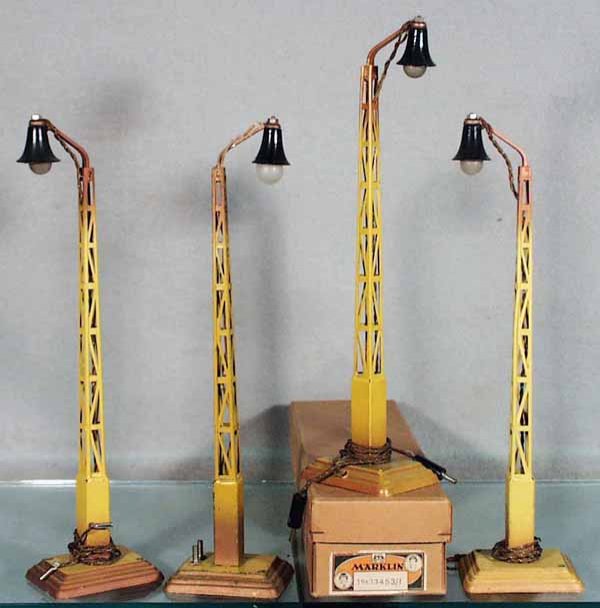 4 MARKLIN 13453/1 LAMP POSTS: handpainted tin, 12 in tall, 1 has a split lamp shade, some paint chipping to bases, 1 orig box only, box has minor wear, C6-7.