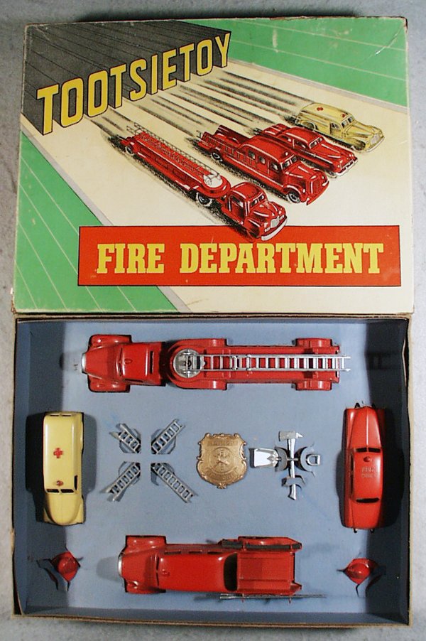 TOOTSIETOY 5211 FIRE DEPARTMENT SET: contains Mack Ladder Wagon, Pumper, Chevrolet Ambulance, paint rub on siren, Mercury Fire Chief, complete w/all accessories, orig box & inserts minor wear, C7-9.