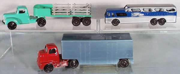 3 TOOTSIETOY VEHICLES: Mack Stake Truck, Greyhound Bus, w/open bottom, International Moving Van, w/plastic trailer, C5-7.