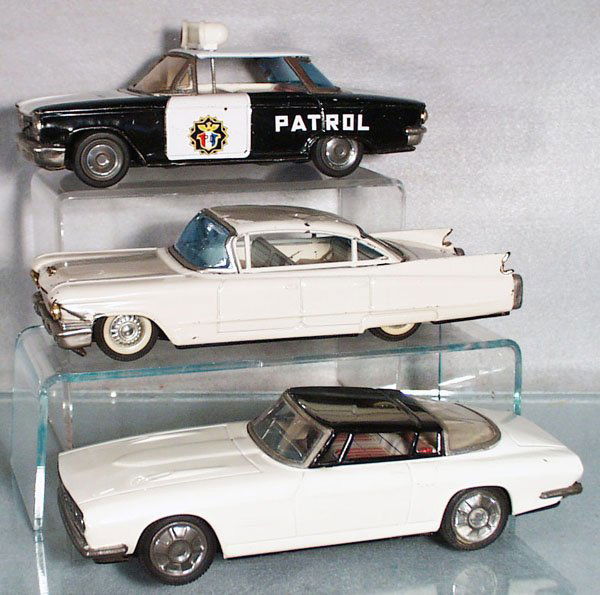 3 JAPANESE AUTOS: litho tin, friction working, Ichiko 1960 Chevrolet Corvair Police Car, some metal trim worn, 9 in long; S&E 1960 Cadillac, front quarter panel has a dent, roof dented, 9 3/4 in long; Ford Mustang Fast