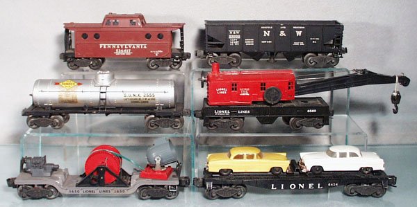 6 LIONEL FREIGHT CARS: O ga, 6417 caboose, New York zone, 3456 operating hopper, 2555 Sunoco tank, decals yellowing, 6560 crane, 3650 searchlight extention car, missing crank, 6424 auto car, both cars worn & 1 has broken bu