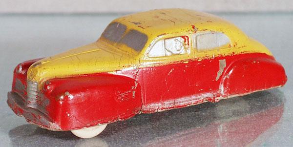 AUBURN RUBBER 1940 OLDSMOBILE: 2-tone, paint worn, 6" long, some cracking to rubber edges, white rubber tires, C3-4.