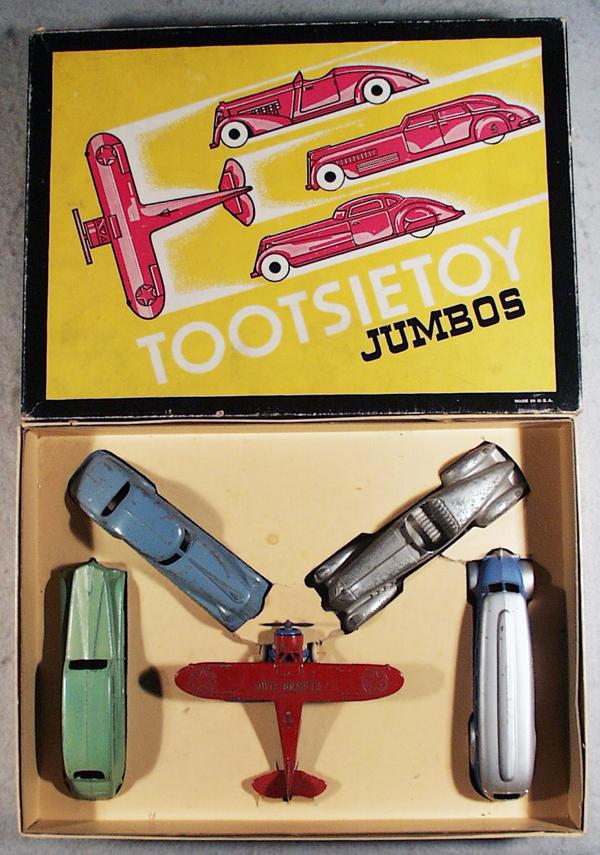 TOOTSIETOY 750 JUMBO SET: contains blue 1017 coupe, silver 1016 roadster, both of these have playwear, green 1018 sedan, blue & silver 1045 Greyhound bus, w/tin chassis, red & blue 718 dive bomber, bottom wings have minor warp