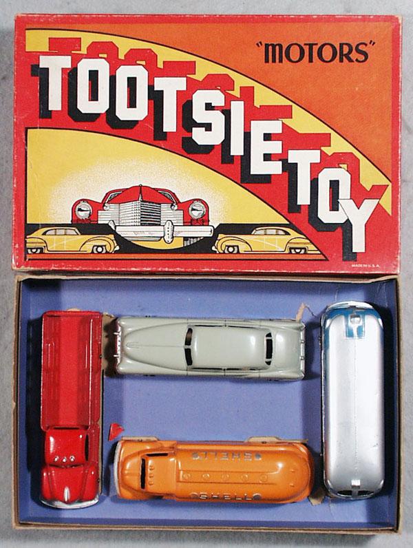 TOOTSIETOY 7250 MOTORS SET: contains gray Cadillac, blue & silver Greyhound Bus, orange Ford Shell Tanker, red International K5 Stake Truck, orig box & insert minor wear, C8-9.