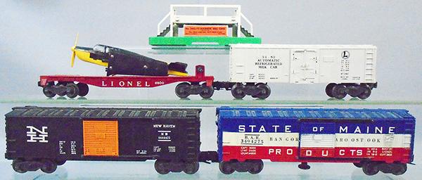 4 LIONEL FREIGHT CARS: O ga, 6800 flat w/airplane, 3482 milk car w/platform, 6464-425 NH box car, w/half serif N, 3494-275 operating SOM box car, orig boxes minor wear, C7-8.