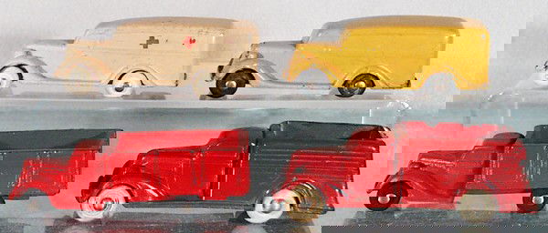 4 RUBBER TRUCKS: 3 Barr Rubber 1935 Ford Trucks - yellow Panel Van, white Ambulance, red Stake Truck, Rainbow Rubber 35 Studebaker Stake Truck, C5-6.