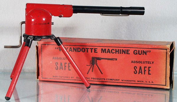 WYANDOTTE 25 MACHINE GUN: painted pressed steel w/wood legs, barrel is 9 1/4" long, working, "Old Orchard ME" rubberstamped on 1 side, orig box rough, C5-6.
