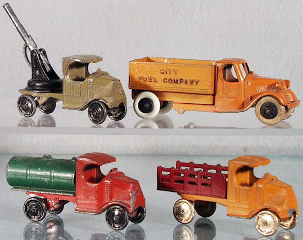 4 TOOTSIETOY MACK TRUCKS: 4643 Anti Aircraft Truck, 804 City Fuel Truck, cracked in half & repaired, 4640 Tanker, 4638 Stake Truck, early version, C4-6.