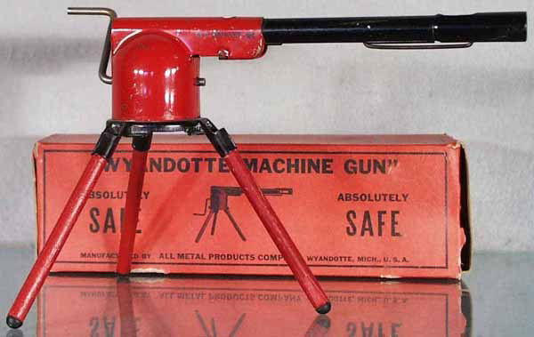 WYANDOTTE 25 MACHINE GUN: painted pressed steel, wooden legs, 9 1/2" long, rubberstamped "Old Orchard ME" on barrel, orig box some wear, C7-8.