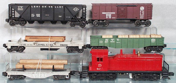 LIONEL TRAIN SET: O ga, 600 MKT switcher, lettering worn, screw crack, 6111 flat w/logs, some oxidation spots, 6462 gondola w/barrels, 3361 log dump, 6436 hopper, some chips on top rail, 6454 box car, C5-6.