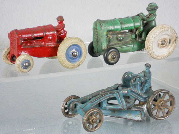 3 FARM TOYS: painted cast iron, 2 Arcade Tractors, red, 3" long, green, 3 1/2" long, w/2 replaced tires, AC Williams Scraper, 4 1/2" long, C4-5.