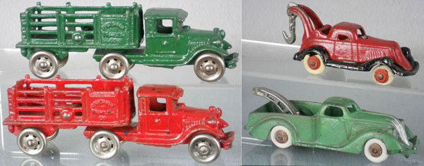 4 CAST IRON TOYS: painted cast iron, 2 AC Williams Coast to Coast Trucks, 7" long, Take-Apart Wrecker, 4 1/2" long, tires worn, Hubley Wrecker, 5 1/2" long, rubber tires replaced, C5.