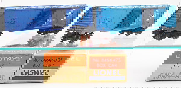 2 LIONEL 6464-475 BOSTON & MAINE BOX CARS: 0 ga, 1st version w/smooth roof, 2nd version in dark blue w/ribbed roof & unpainted body, orig boxes, 1 minor wear, late box worn, all flaps intact, C8-9.