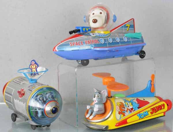 3 TM SPACE TOYS: litho tin & plastic, Apollo Capsule, scuff on nose plastic, floating man damaged, 9 1/2" long, Snoopy Space Patrol, 11" long, Tom & Jerry Helicopter, 9 1/2" long, all are battery operated, not tested,