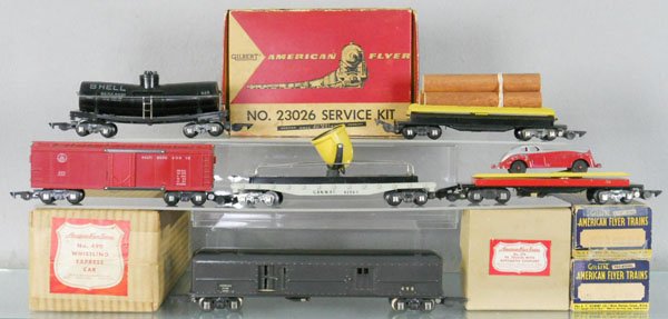AMERICAN FLYER TRAIN LOT: S ga, 490 whistling baggage, 625 Shell tank, warped, 633 reefer, 634 searchlight, 715 auto unloading, 717 log car, 23026 service kit, 676 pair of trucks, 6 orig boxes only, boxes worn, C5-9.