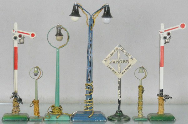 7 MARKLIN ACCESSORIES: O ga, 2 #12337 semaphores, 1 missing light cap, 13452 double lamp post, danger sign has paint flaking, 3 lamp posts, C5-6.