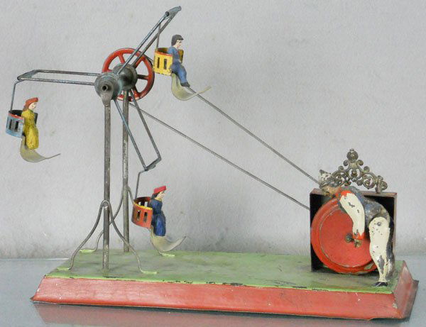 GERMAN 3-SEAT FERRIS WHEEL: handpainted tin, 12" long, windup working, w/3 composition riders, windup mechanism resoldered, C5-6.