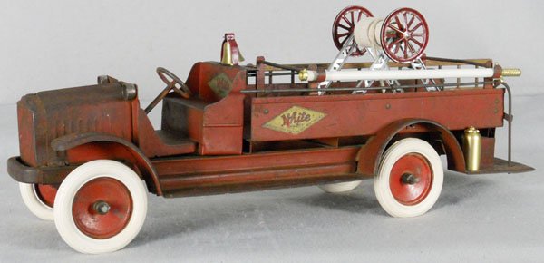 KELMET WHITE FIRE HOSE TRUCK: painted pressed steel, 26 1/2" long, rubber tires, hose, ladder, bell & harp, fire extinguishers replaced, w/removable hose reel, decals worn, some surface oxidation, C3-4.