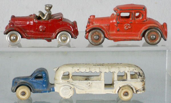 3 CAST IRON VEHICLES: painted cast iron, Kilgore Ford Roadster, 3" long, AC Williams Ford, 3 1/2" long, Arcade GMC Greyhound Bus, 5 1/2" long, C5-6.