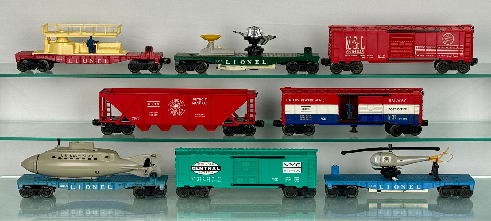 8 Lionel freight cars: A collection of Lionel Post-War rolling stock, comprising nine vintage model train cars, accompanied by eight original Lionel cardboard boxes. The collection includes diverse types such as a red "M.S.