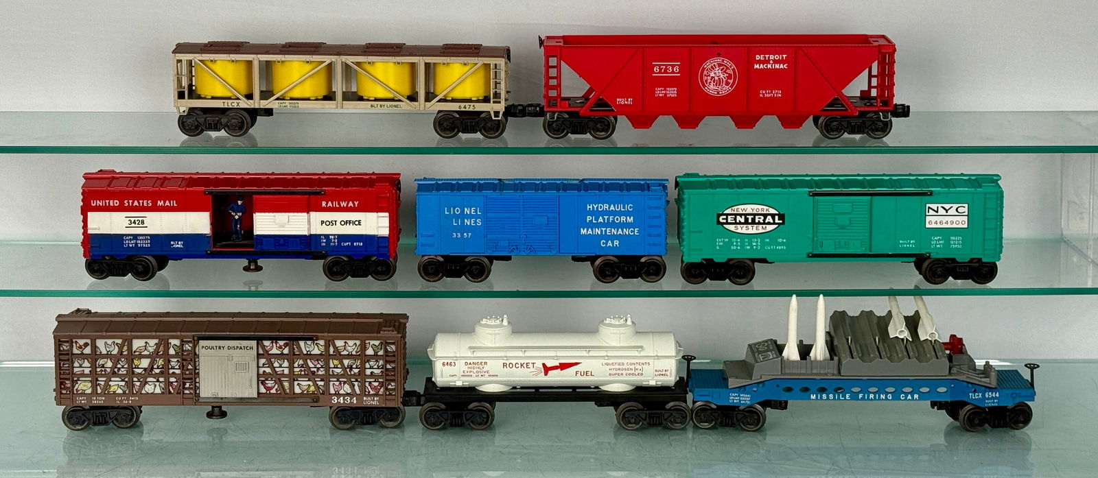 8 Lionel Freight Cars: 8 Lionel Post-War O-Gauge model train cars, The collection features a diverse range of freight and specialty cars, including a "PICKLES" tank car (model 6475), a "DETROIT MACKINAC" hopper (model 6736)