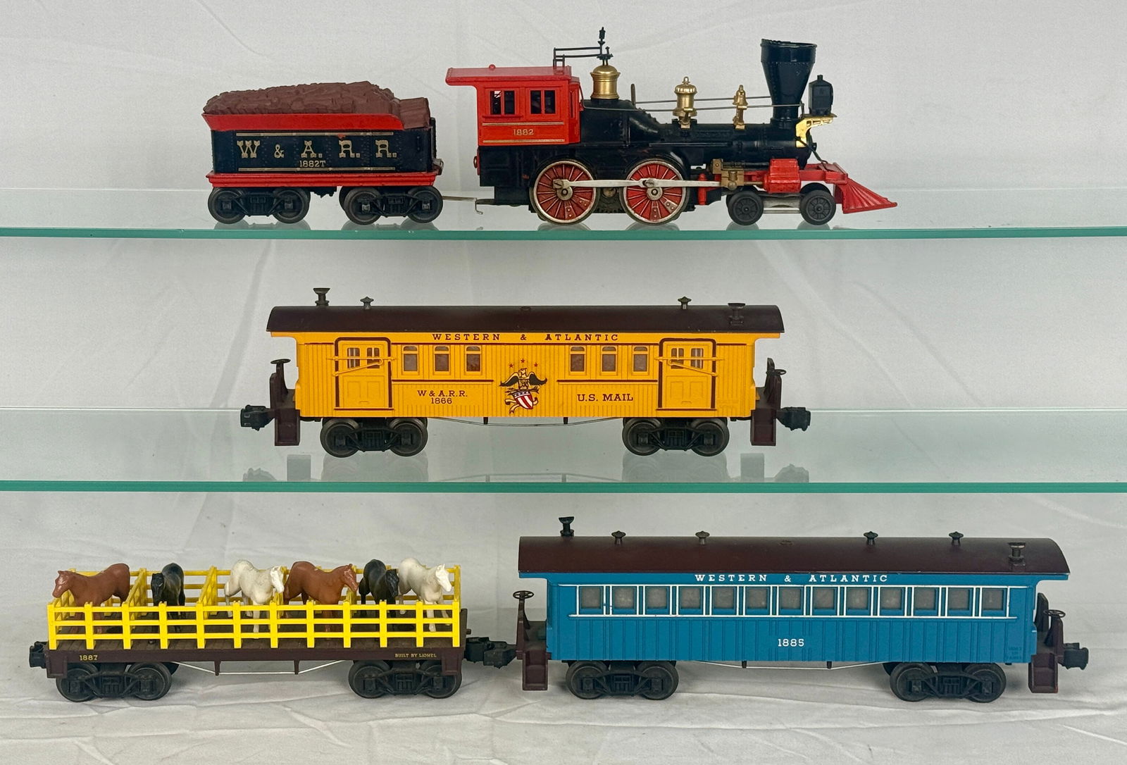 Lionel O-Gauge 'Halloween General' Train Set: A Lionel Postwar O-Gauge 'Halloween General' Train Set, comprising five components. The set includes a black and red 4-4-0 steam locomotive (cab marked "1863") and an accompanying tender (marked "W. &